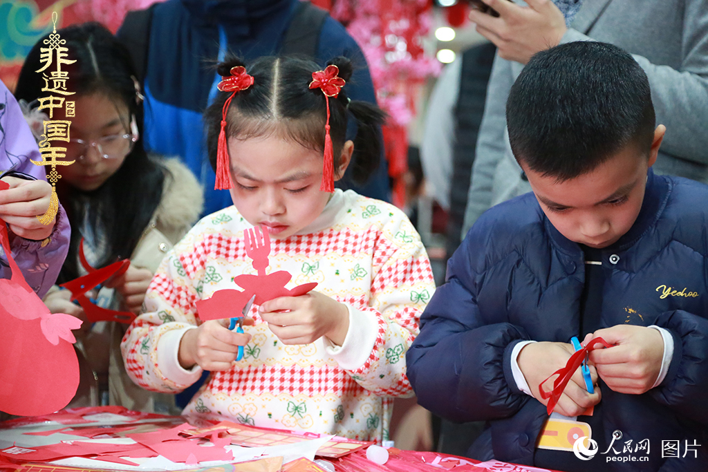 2025年1月23日，上海市青少年活動中心迎新春游園會上，小朋友們正在學習剪窗花。人民網(wǎng)記者 龔莎攝