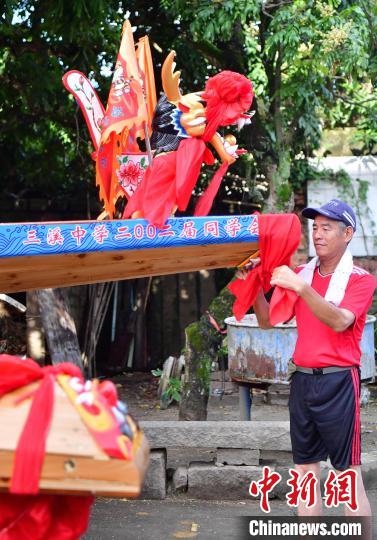 圖為5月29日，長樂江田鎮(zhèn)村民為即將入水的新龍舟系紅布?！埍?攝