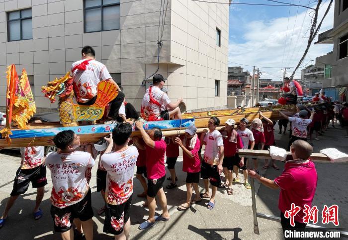 圖為5月29日，長樂江田鎮(zhèn)村民們肩扛著新龍舟舉行入水前游街儀式?！埍?攝