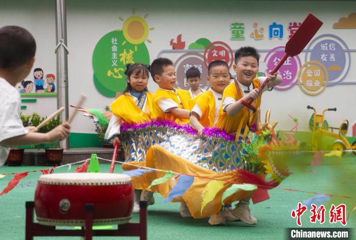 圖為龍舟賽游戲上，小伙伴們打鼓加油?！《^生 攝
